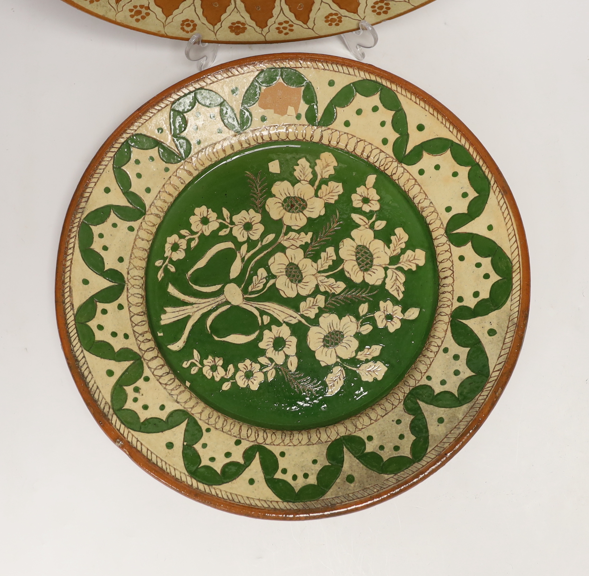 Two Portuguese glazed and incised pottery chargers, 36cm diameter
